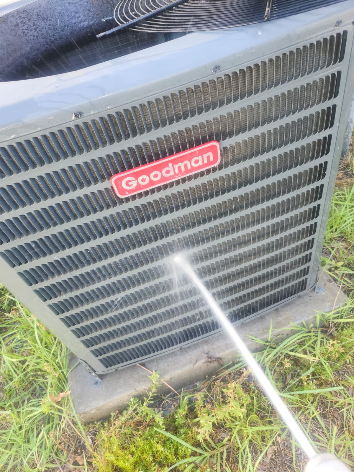 Goodman AC Cleaning - Tampa, FL 33611 Cleaning Goodman outdoor AC unit with hose in Tampa, FL 33611.