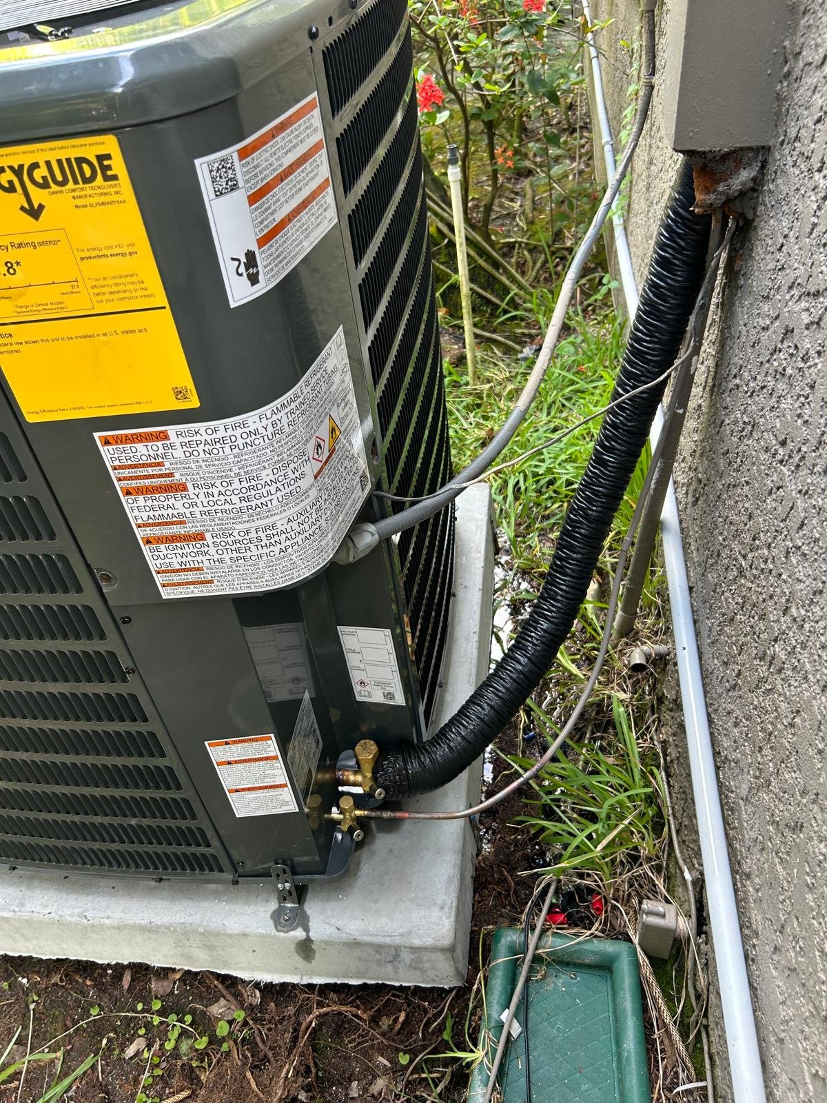 Side view of Goodman AC unit with pipes and wires, Oldsmar, FL 34677.