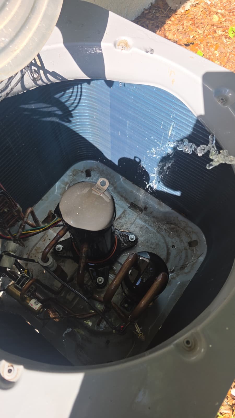 Water being sprayed inside an HVAC unit for cleaning in Tampa, FL 33610.