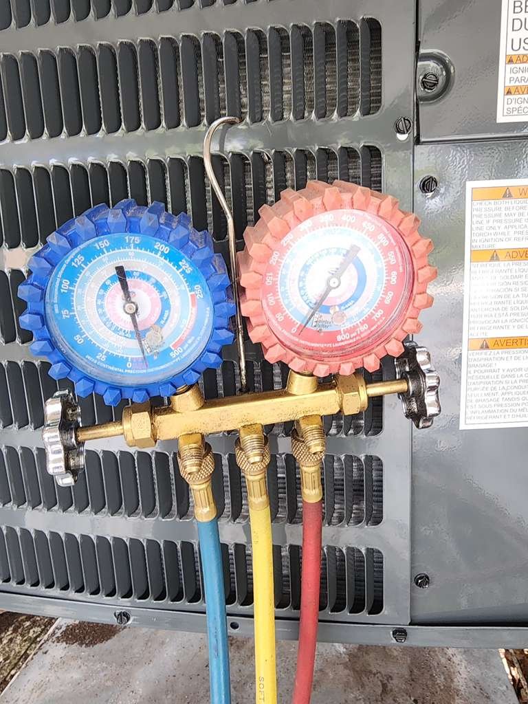Close-up of HVAC gauges attached to an outdoor unit in Tampa, FL 33618.