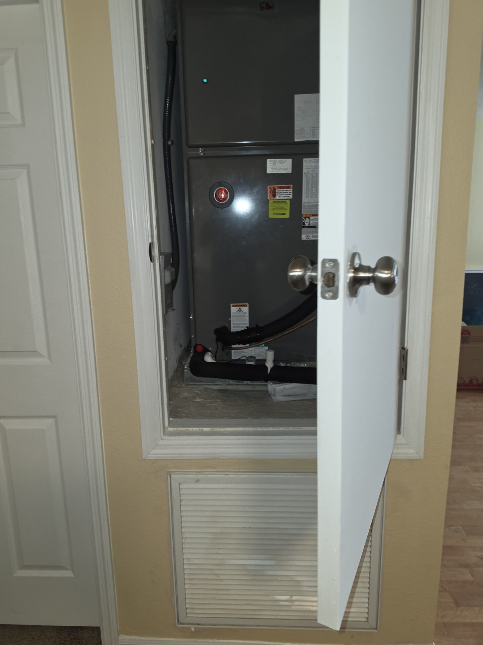 HVAC unit with open closet door, installation in Lutz, FL 33558.