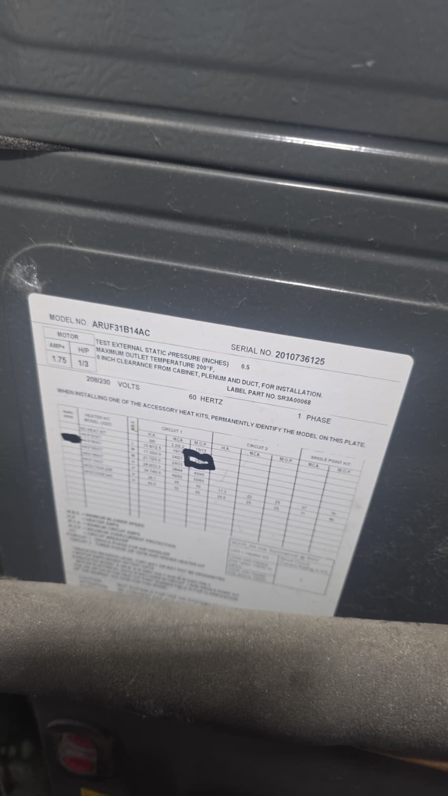Close-up of model and serial number label on HVAC unit in Tampa, FL 33611.