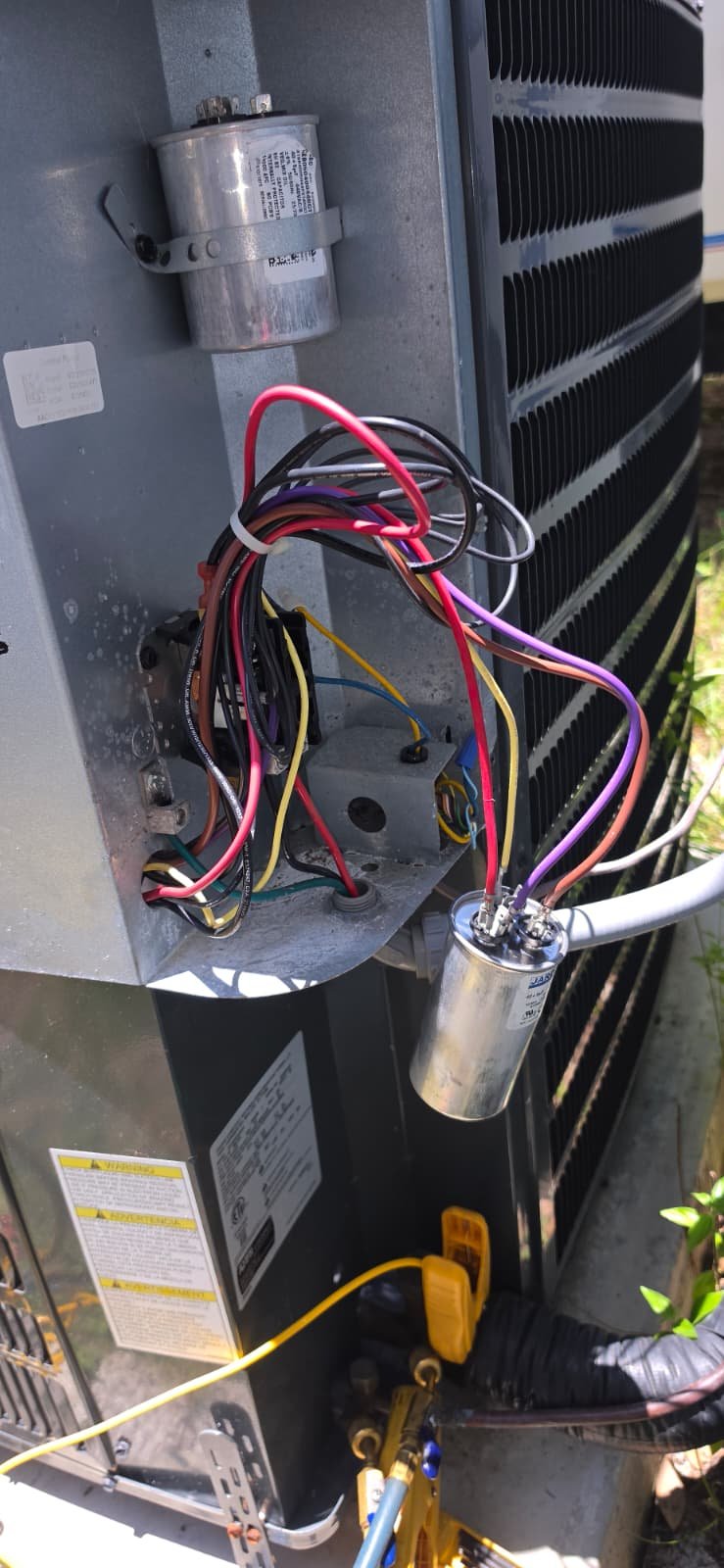 HVAC Unit Repair - Tampa, FL 33611 Open HVAC unit with visible wiring and capacitor replacement in Tampa, FL 33611.
