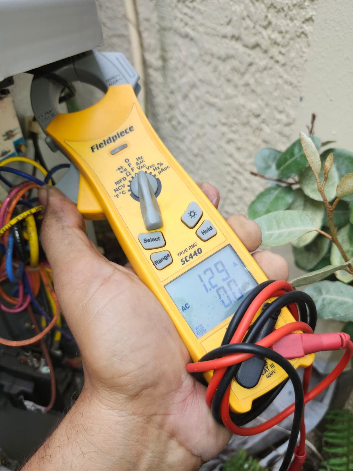 Checking HVAC unit with multimeter in Tampa, FL 33647.
