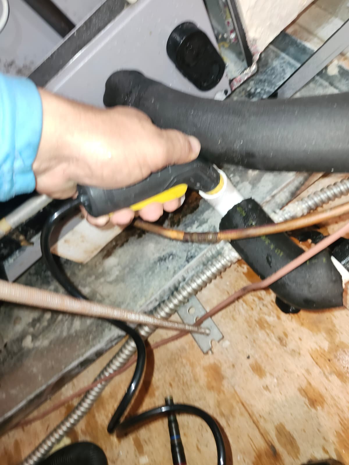 Person flushing a drain line with a hose in a mechanical room, New Port Richey, FL 34655.