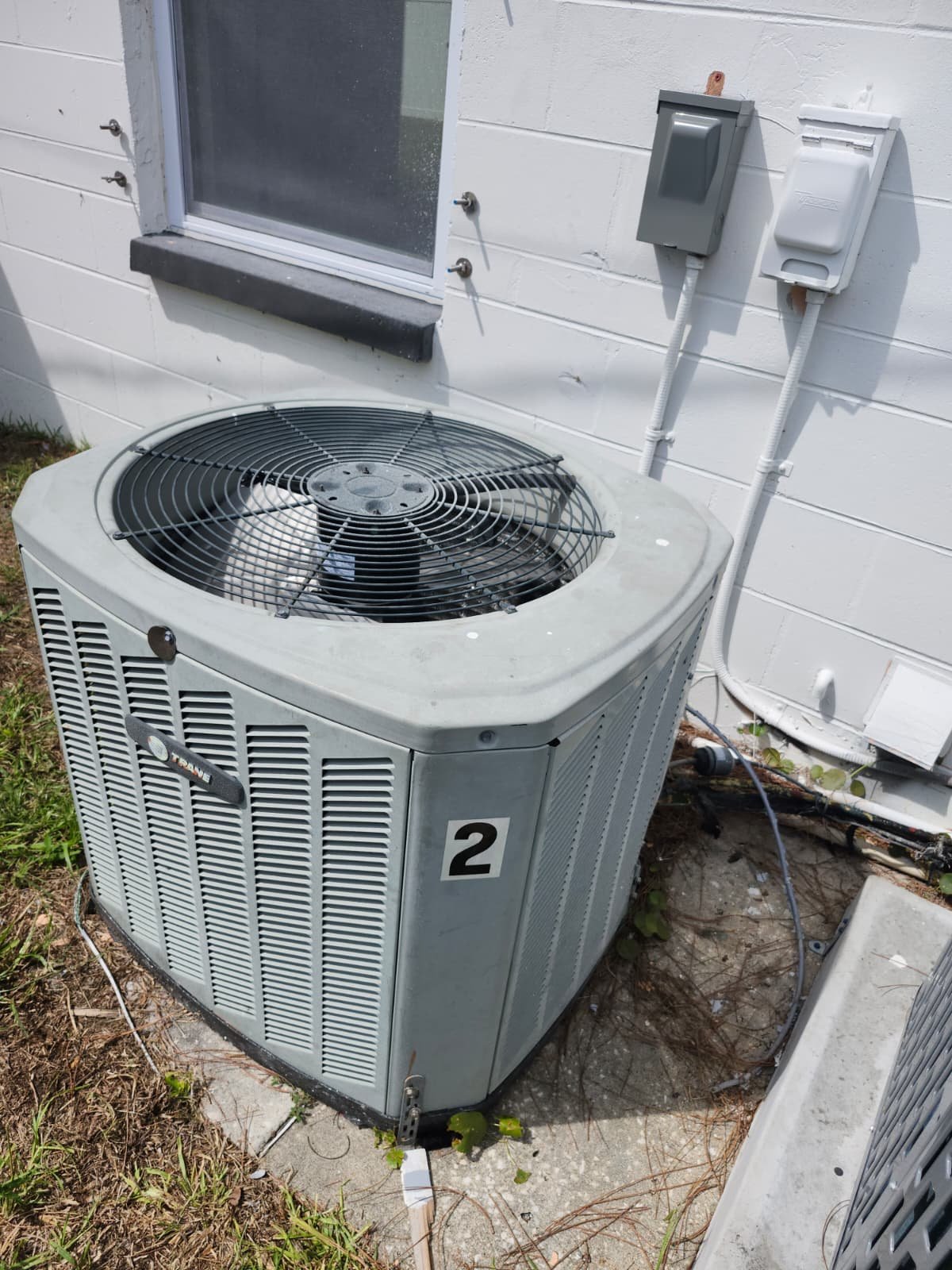 Installed AC unit with visible disconnect switch on wall in St. Petersburg, FL 33712.