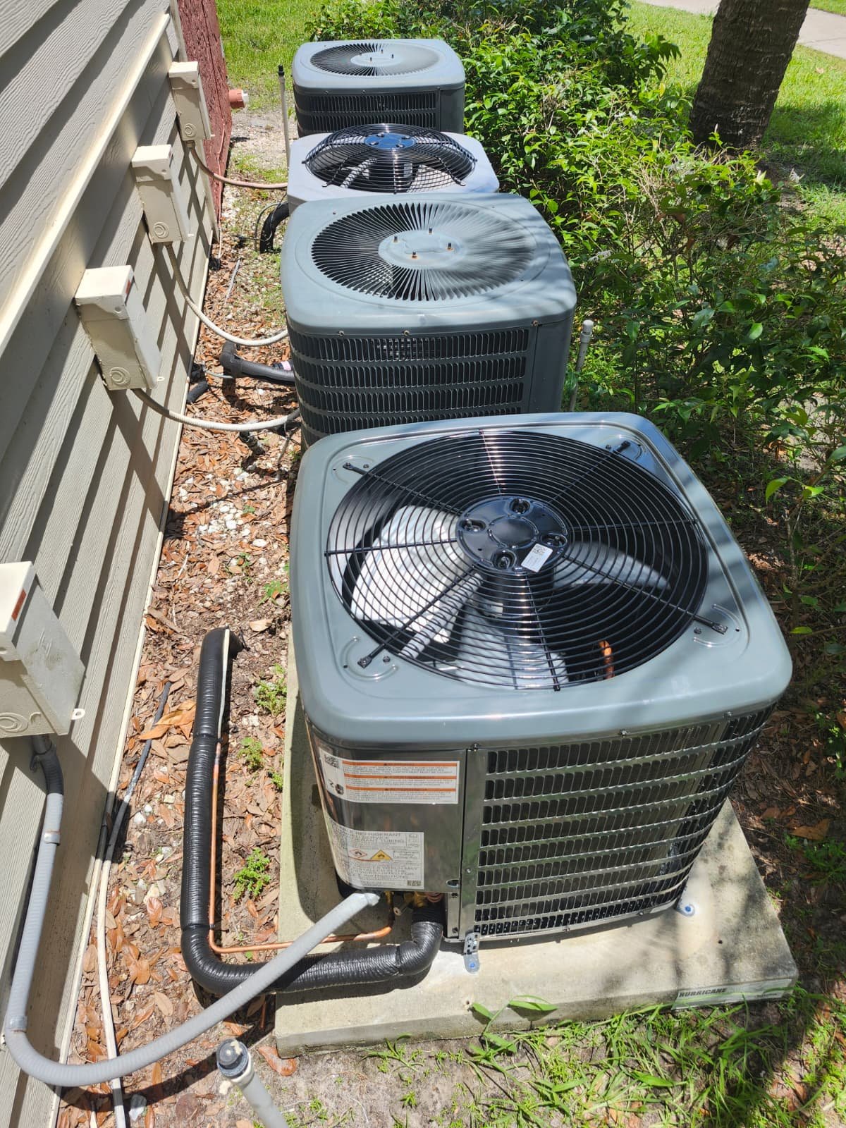 Multiple outdoor AC units installed in a line in Brandon, FL 33511. Efficient cooling solutions.
