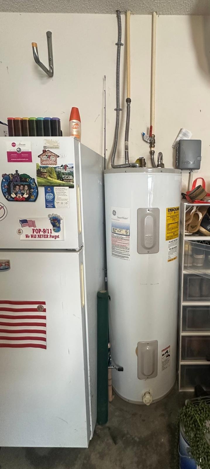 Old Water Heater Before Replacement - Tampa, FL 33624 Old water heater next to refrigerator in Tampa, FL 33624 garage. Pre-replacement view.