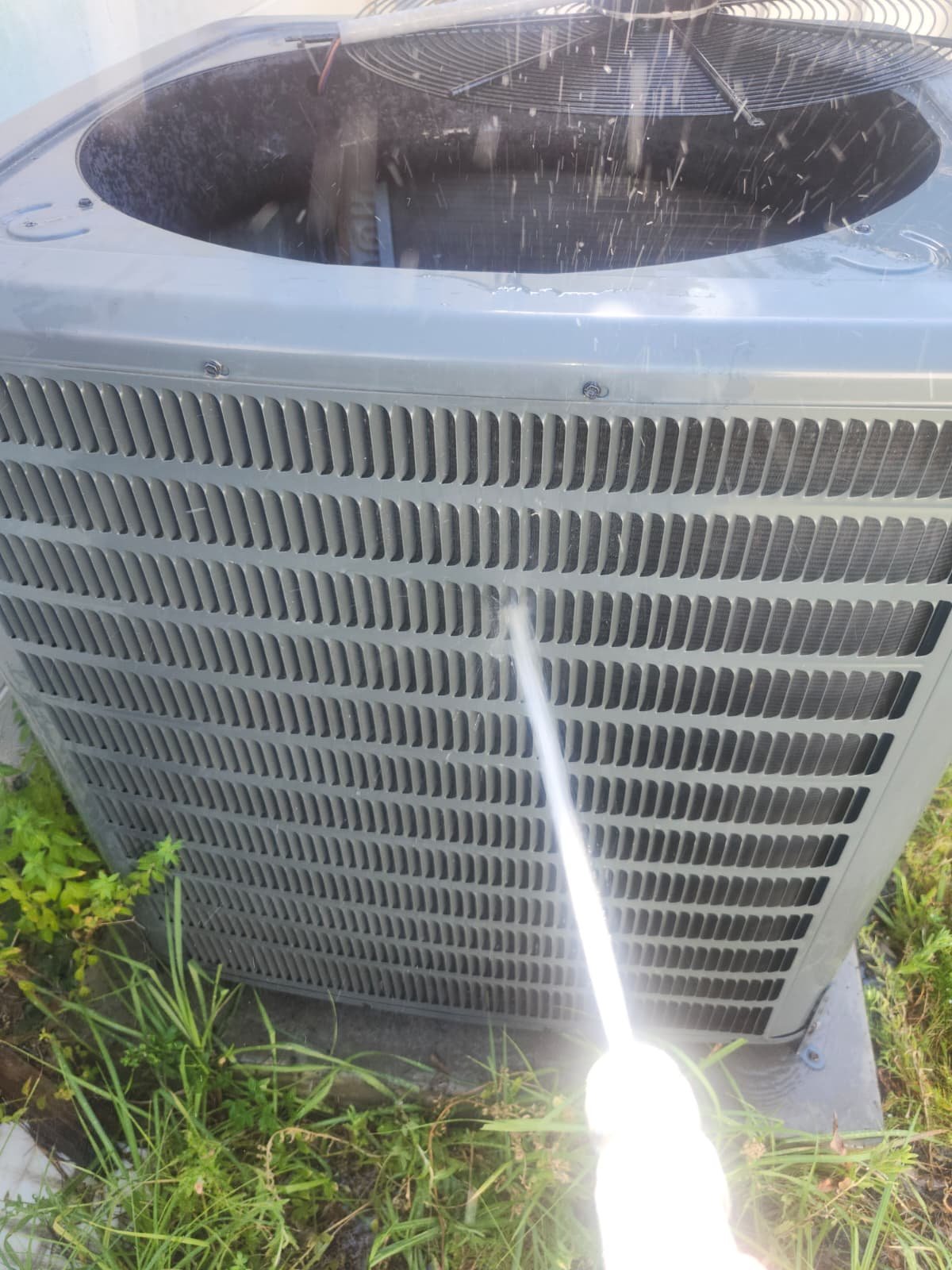Outdoor AC Cleaning - Tampa, FL 33611 Cleaning outdoor AC unit with hose in Tampa, FL 33611 during Visit #1.
