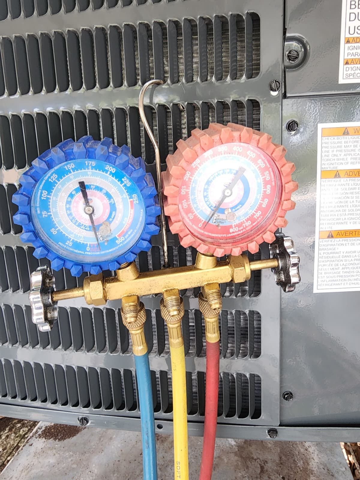 Close-up of HVAC gauges attached to an outdoor unit in Tampa, FL 33618.