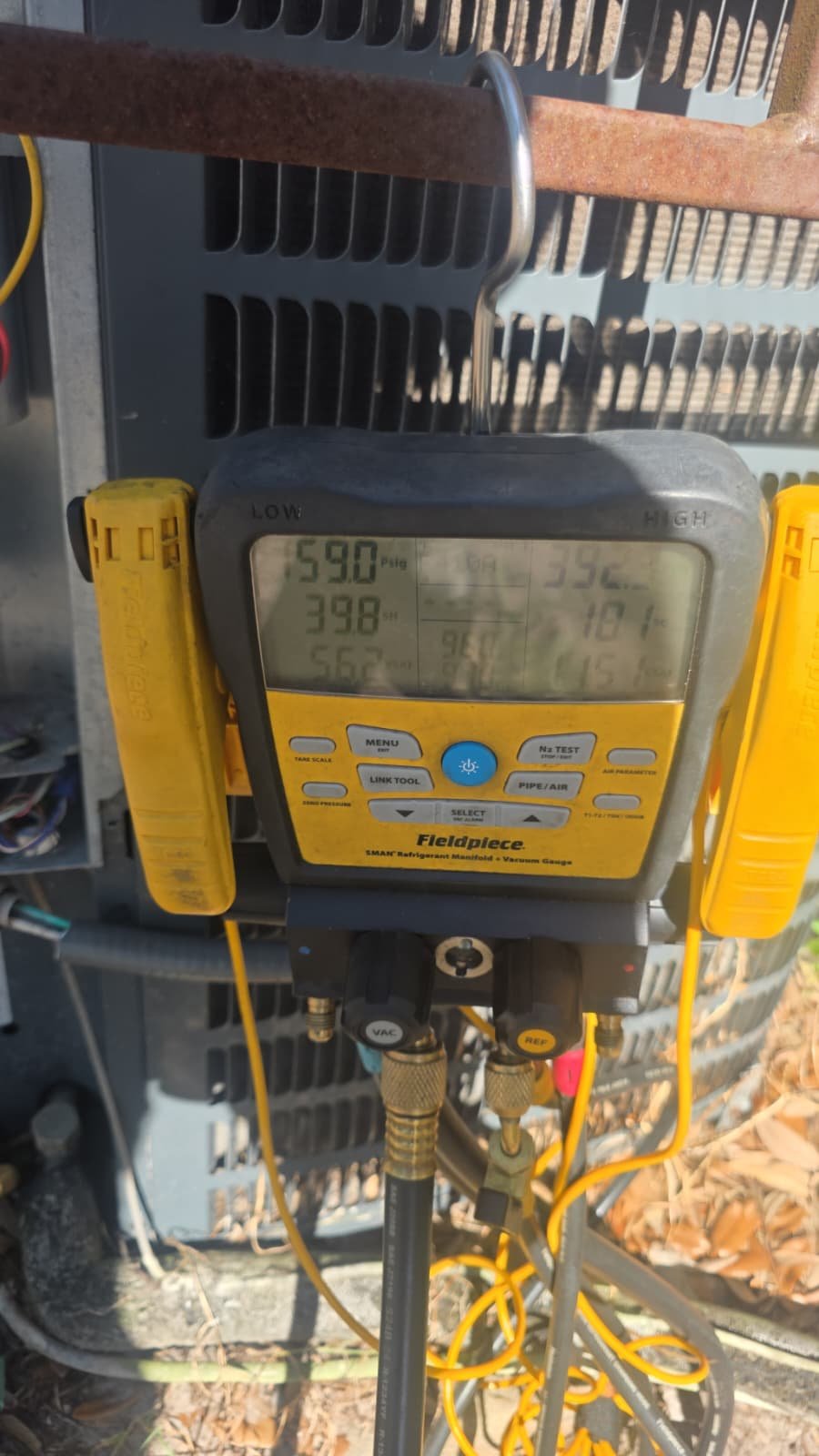 Digital manifold gauge with pressure readings on AC unit in Tampa, FL 33611.