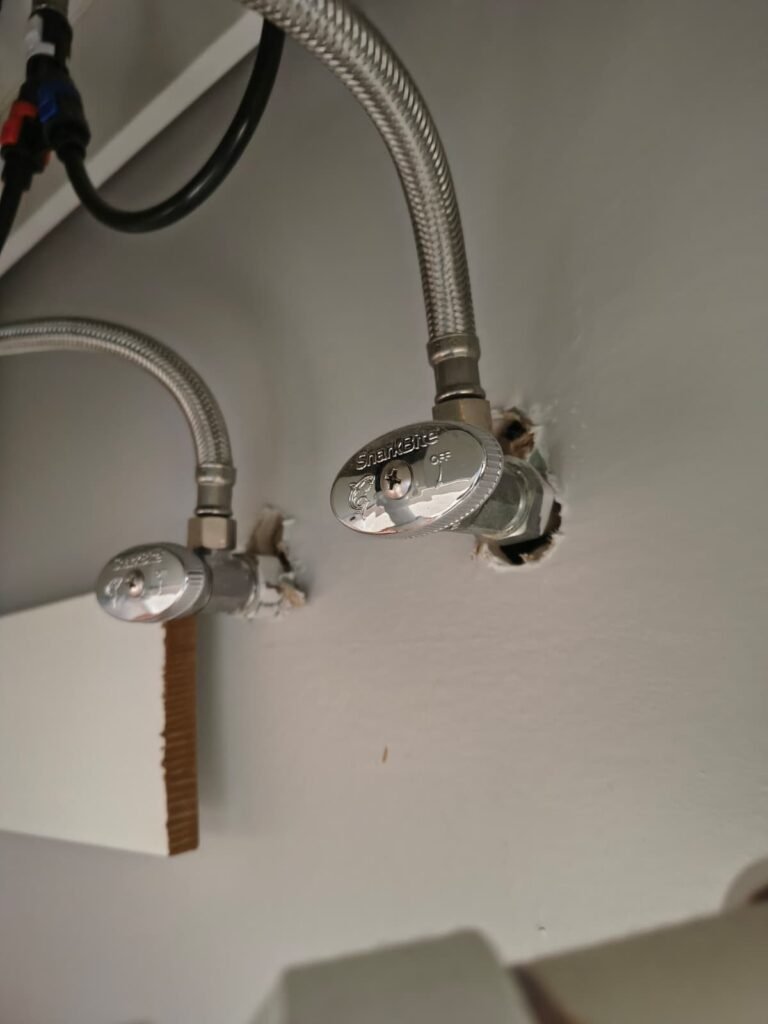 Shut-off valves and supply lines under a sink in Tampa, FL 33615.