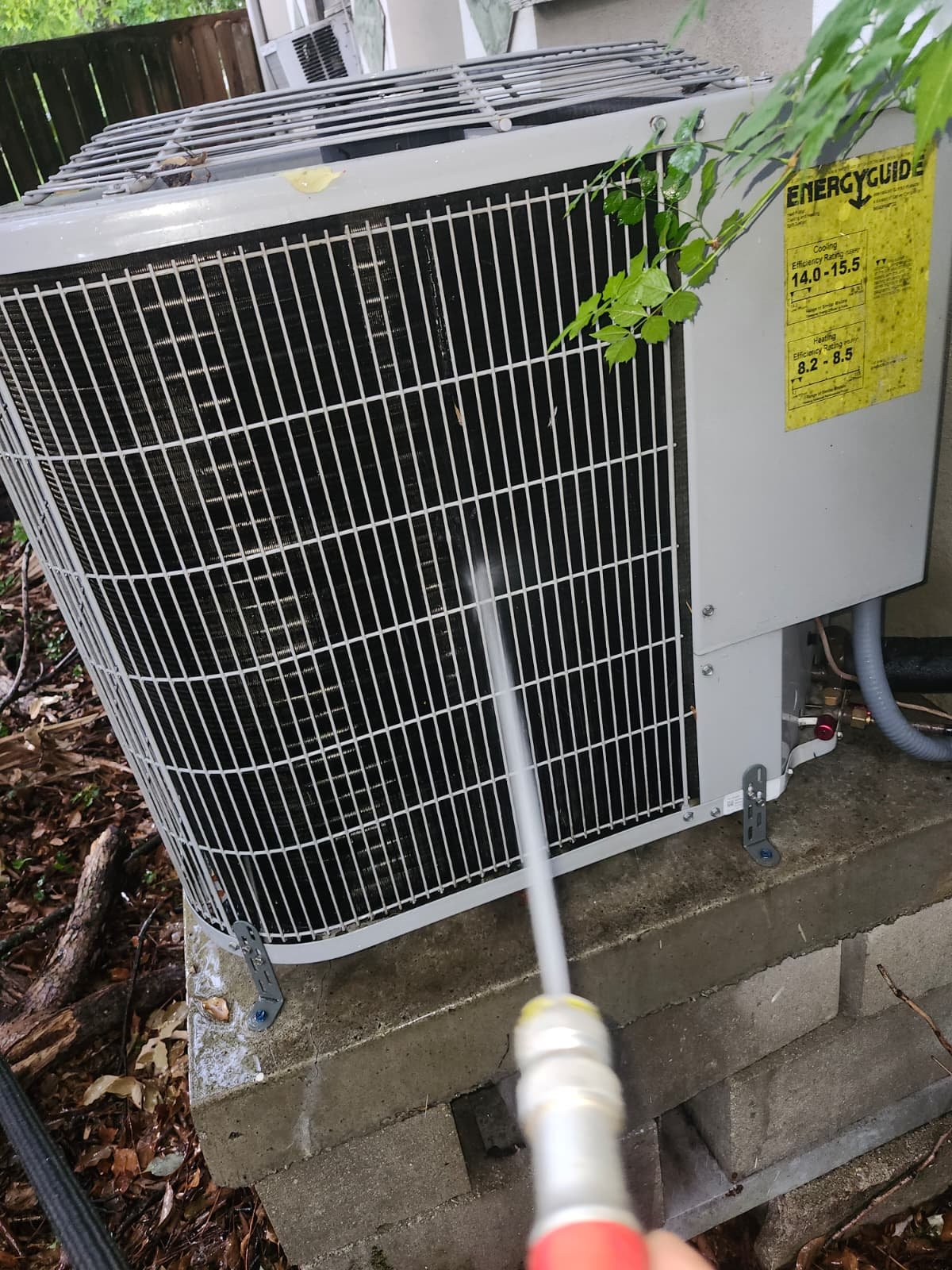 Spraying Outdoor AC Unit - Tampa, FL 33604 Spraying water on outdoor AC unit for cleaning at 1300 Alicia Avenue, Tampa, FL 33604.