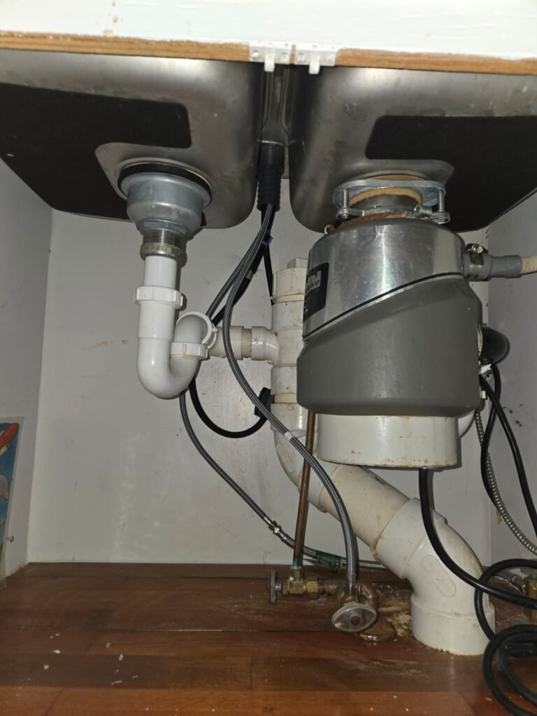 Under-sink drain lines, P-trap and garbage disposal in a Riverview, FL 33569 kitchen.