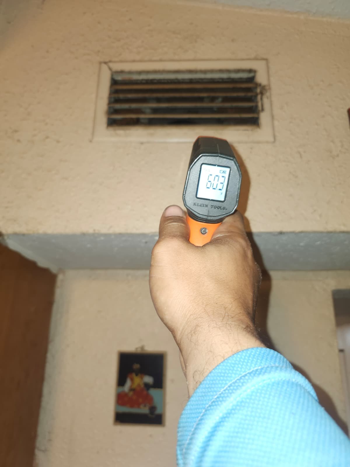 Thermometer reading at wall air vent during system repair in Tampa, FL 33604.