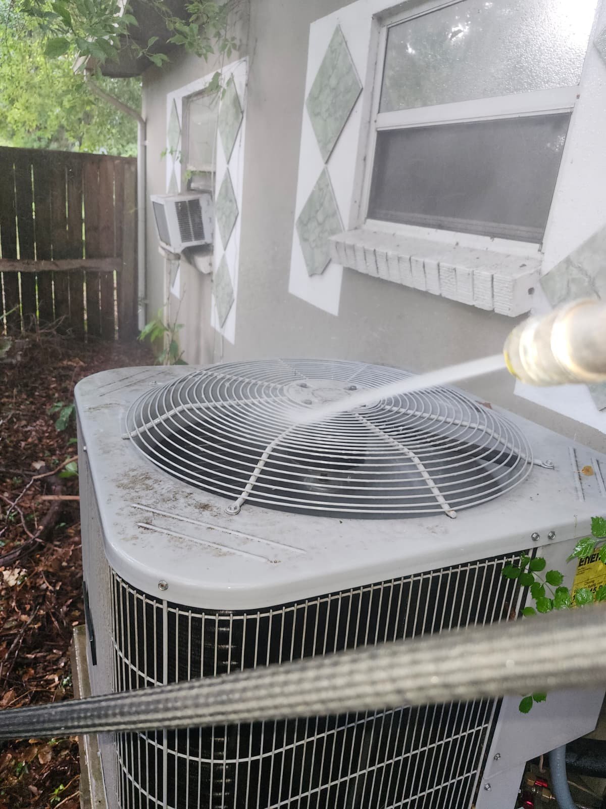 Washing Outdoor AC Unit - Tampa, FL 33604 Washing top of outdoor AC unit with hose at 1300 Alicia Avenue, Tampa, FL 33604.