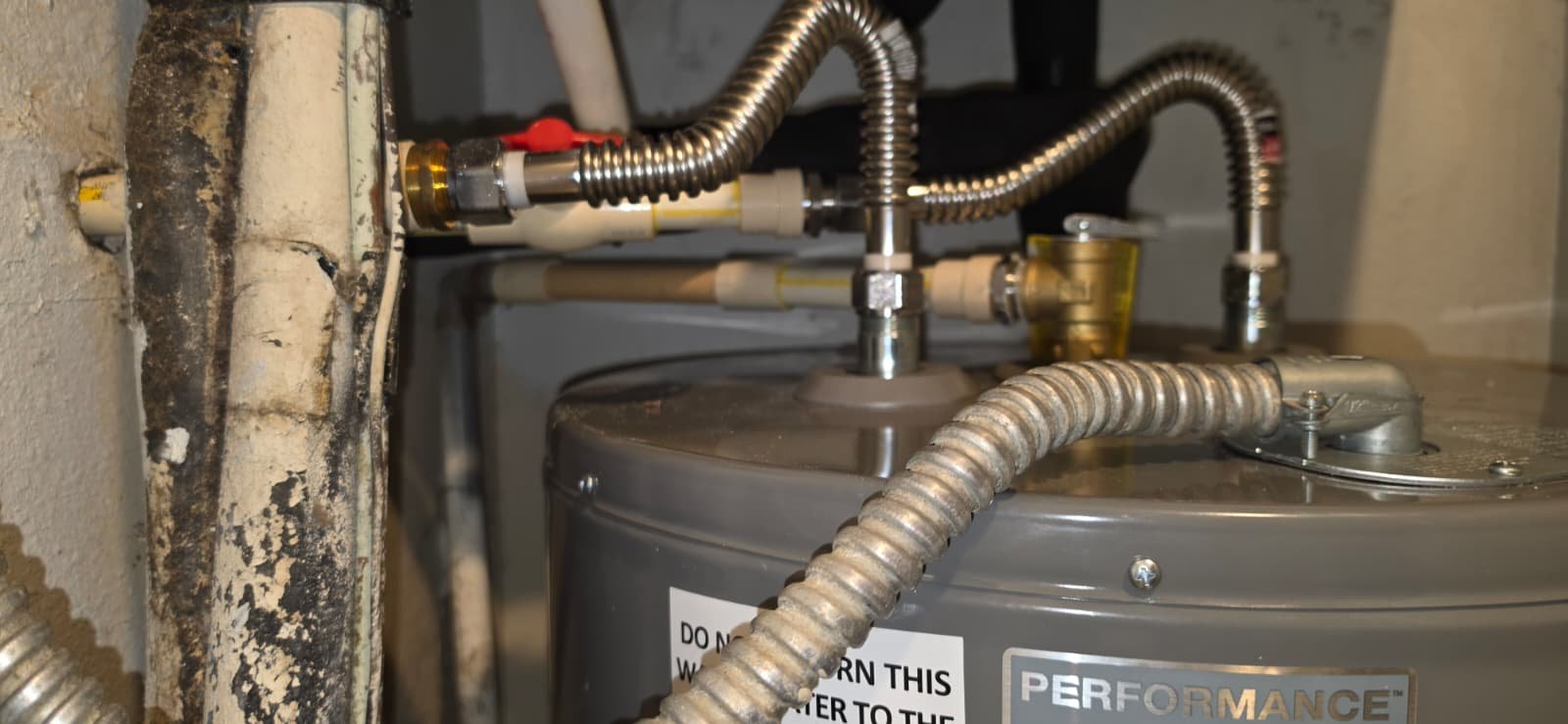Water heater with plumbing and labels in Brandon, FL 33511. Equipment focus.