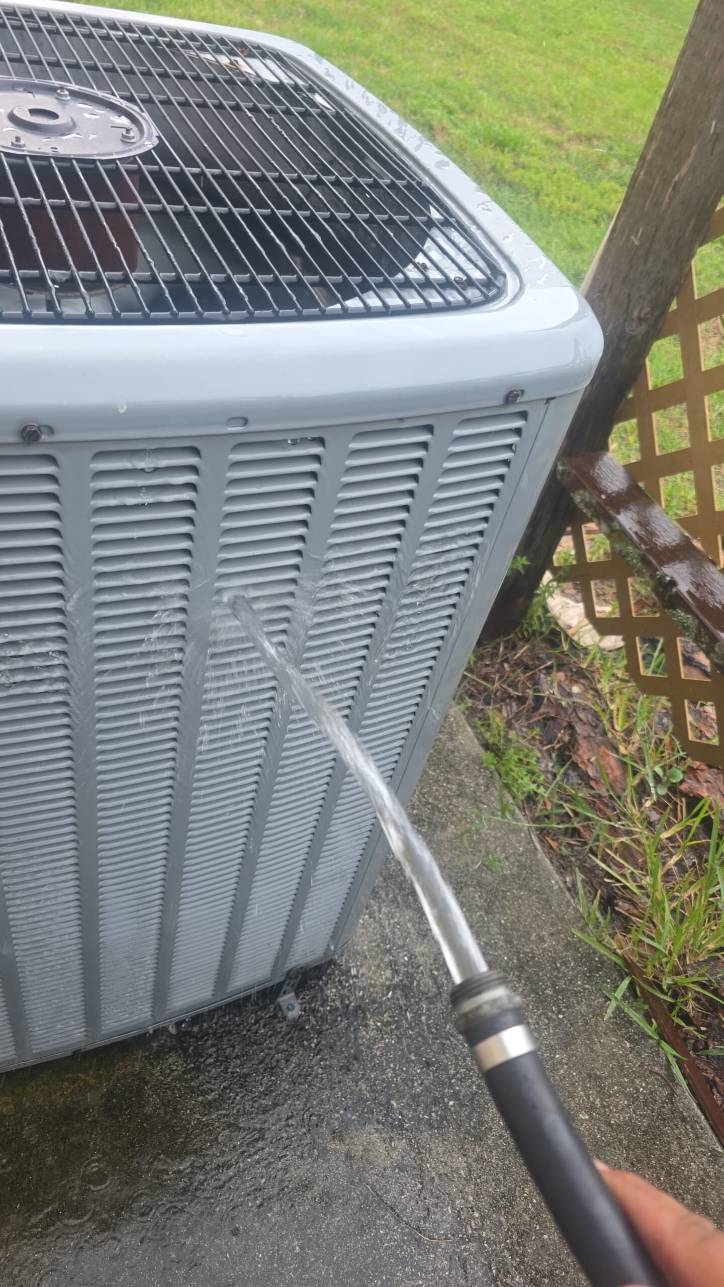 Water hose cleaning outdoor AC unit, Elite Therapy Visit #7, Bradenton, FL 34202.