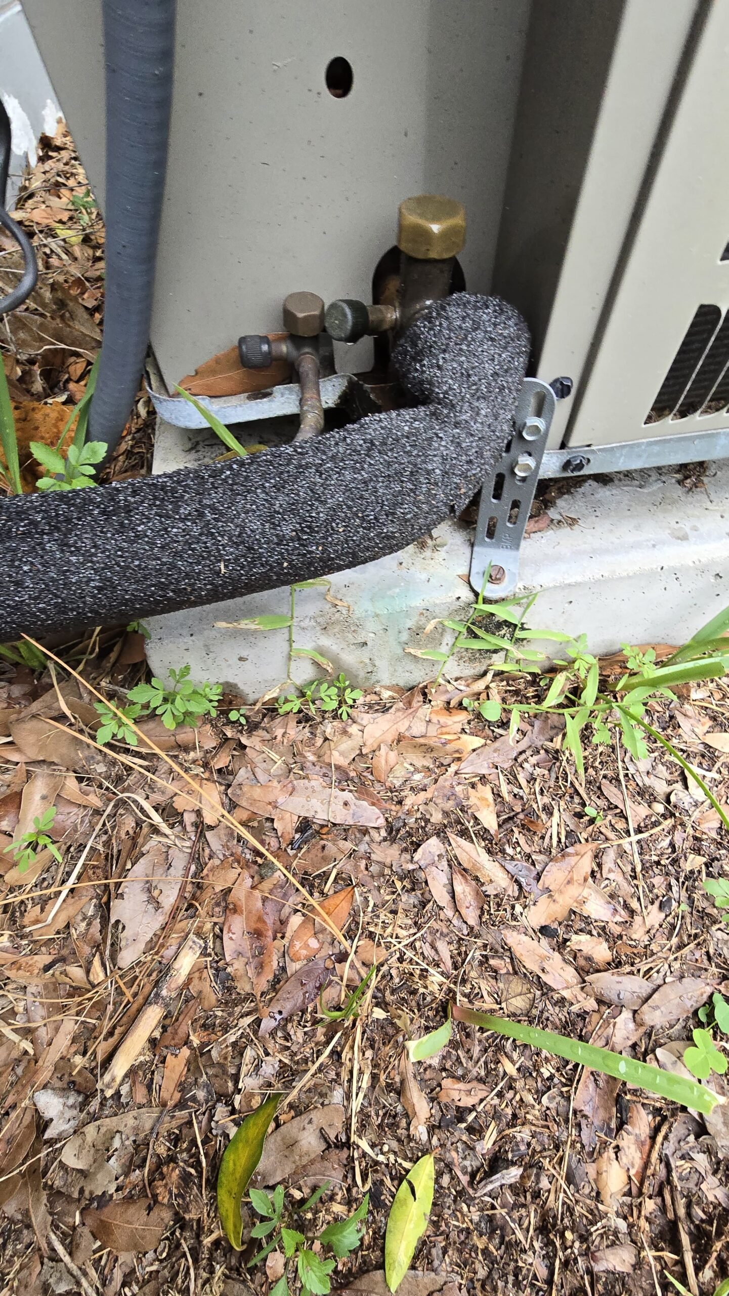 Close-up of AC unit connections and insulation in Tampa, FL 33613.
