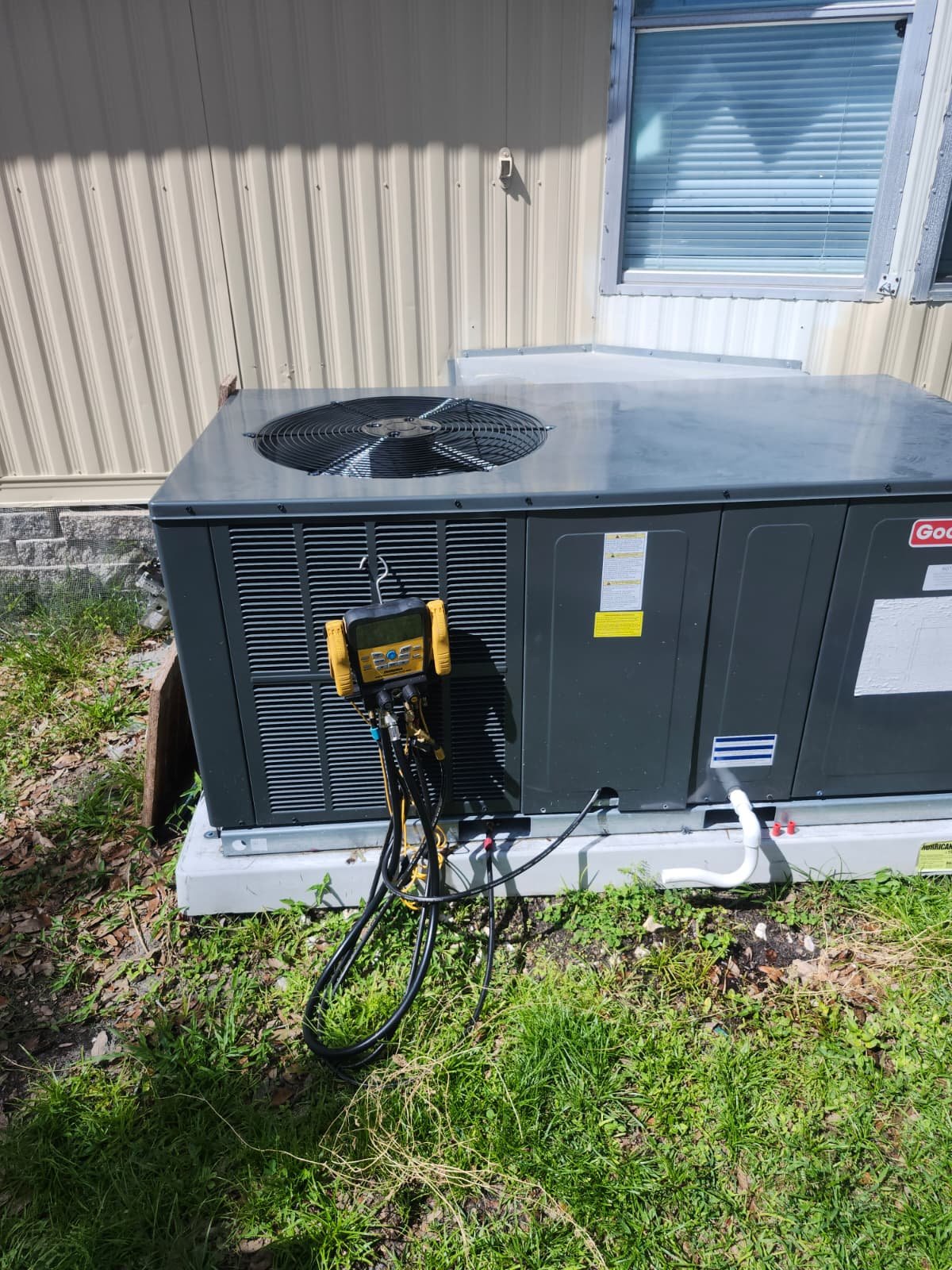 Goodman AC unit with diagnostic tools attached in Odessa, FL 33556. Ensuring optimal performance.