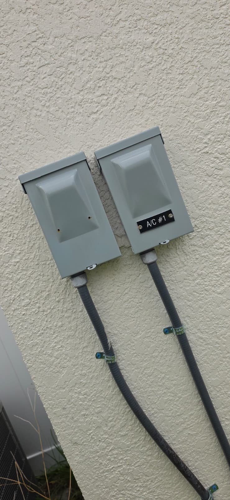A/C Disconnect Boxes - Spring Hill, FL 34609 Exterior view of A/C disconnect boxes in Spring Hill, FL 34609. Part of HVAC system setup.