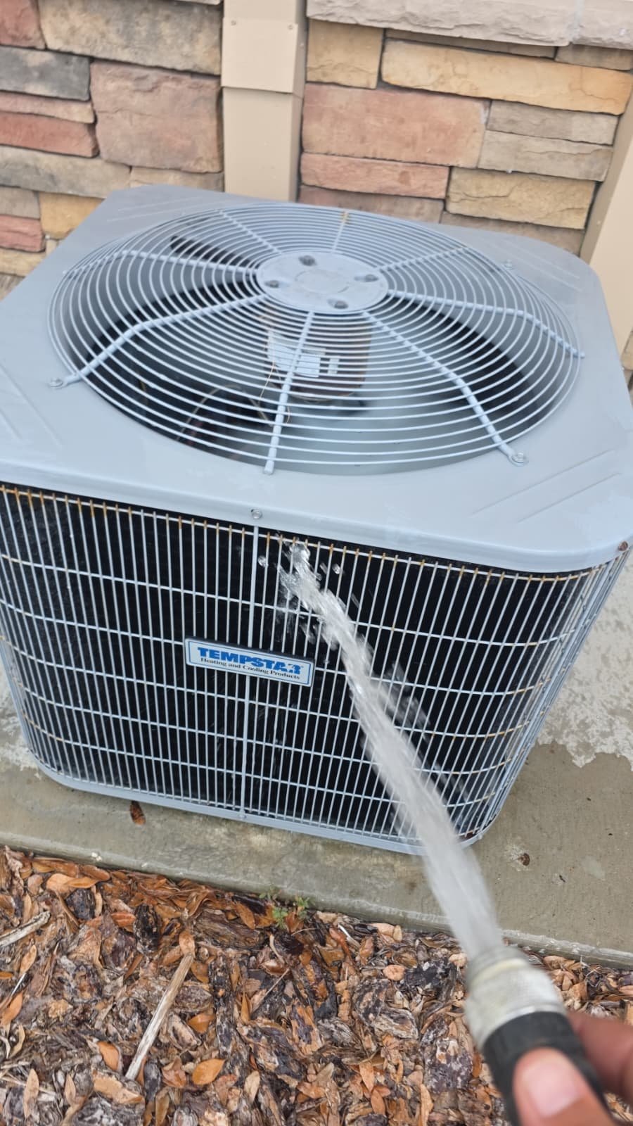 AC Unit Cleaning in New Port Richey, FL 34655 Outdoor AC unit being cleaned with a hose in New Port Richey, FL 34655.