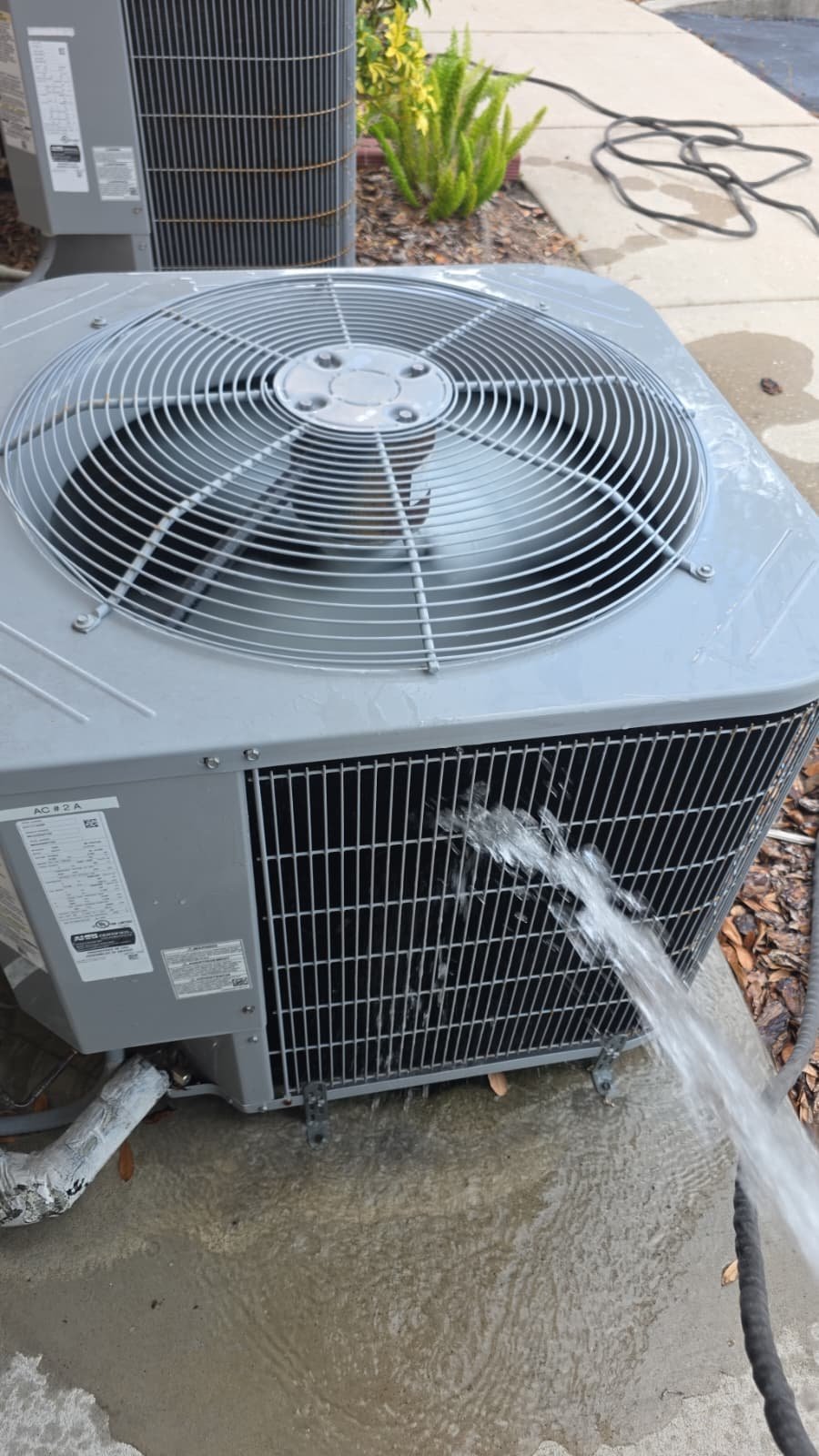 AC Unit Cleaning in New Port Richey, FL 34655 Outdoor AC unit being cleaned with a hose in New Port Richey, FL 34655.