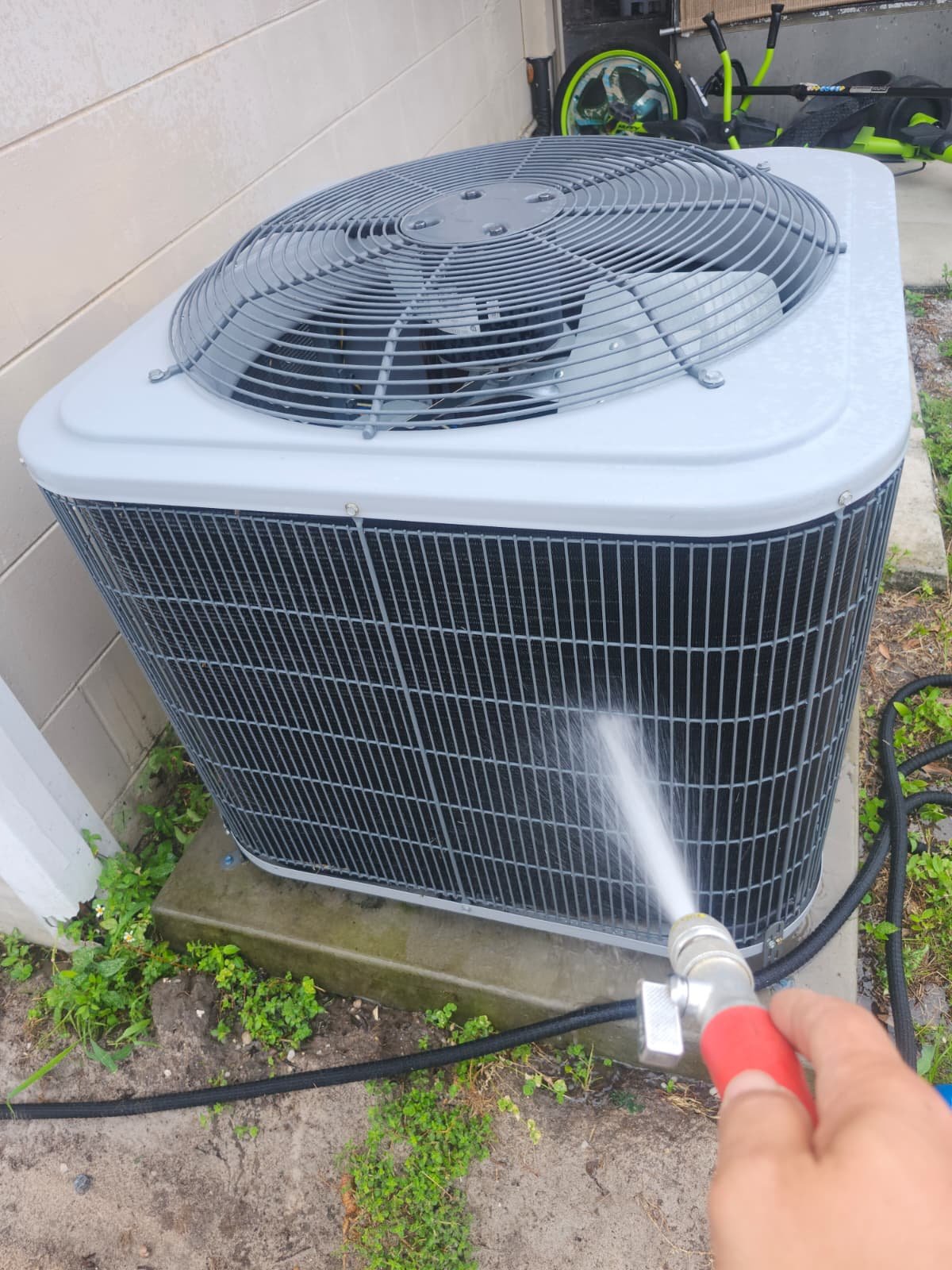 AC Unit Cleaning - Tampa, FL 33614 Outdoor AC unit being cleaned with a hose in Tampa, FL 33614. Part of Premium Therapy Plan.