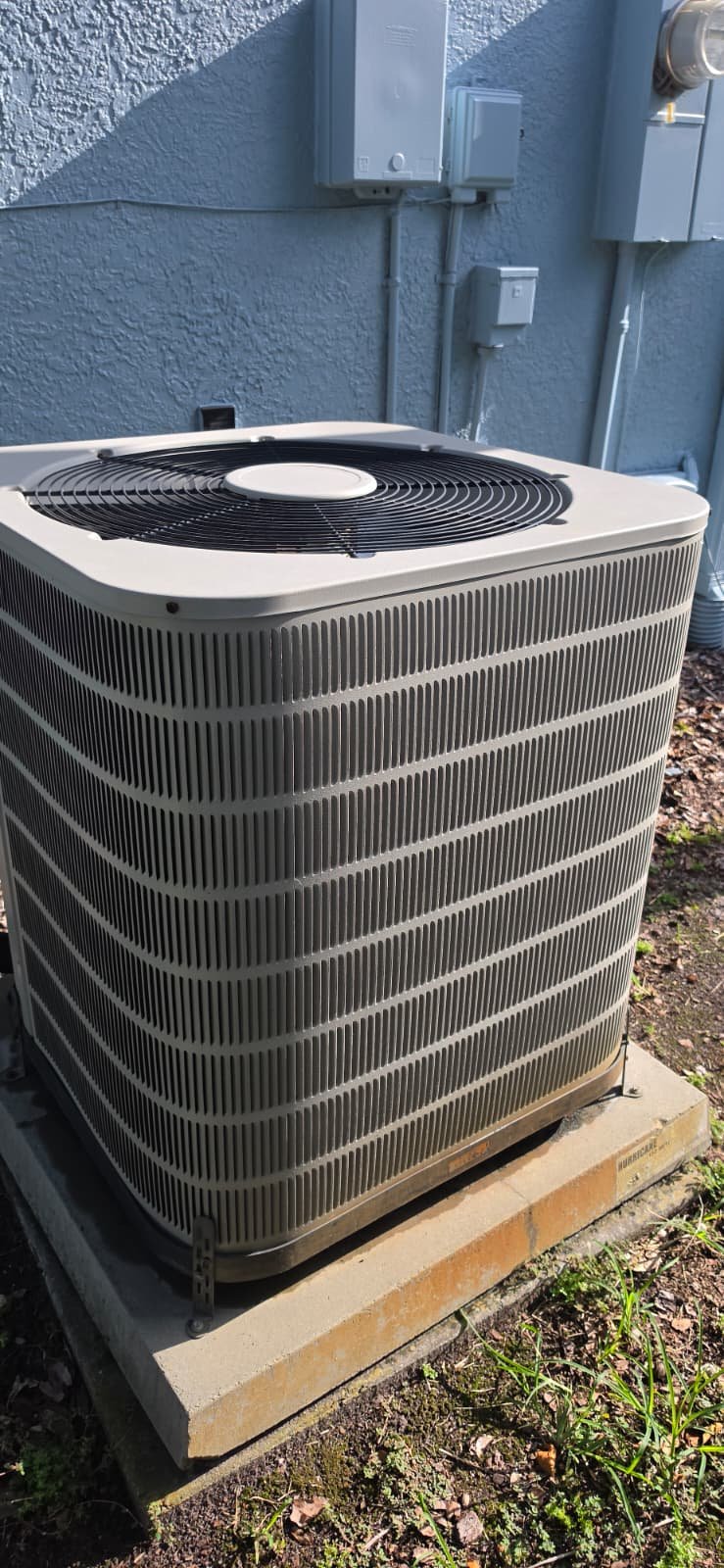 Close-up of outdoor AC unit fan and housing in Tampa, FL 33624.