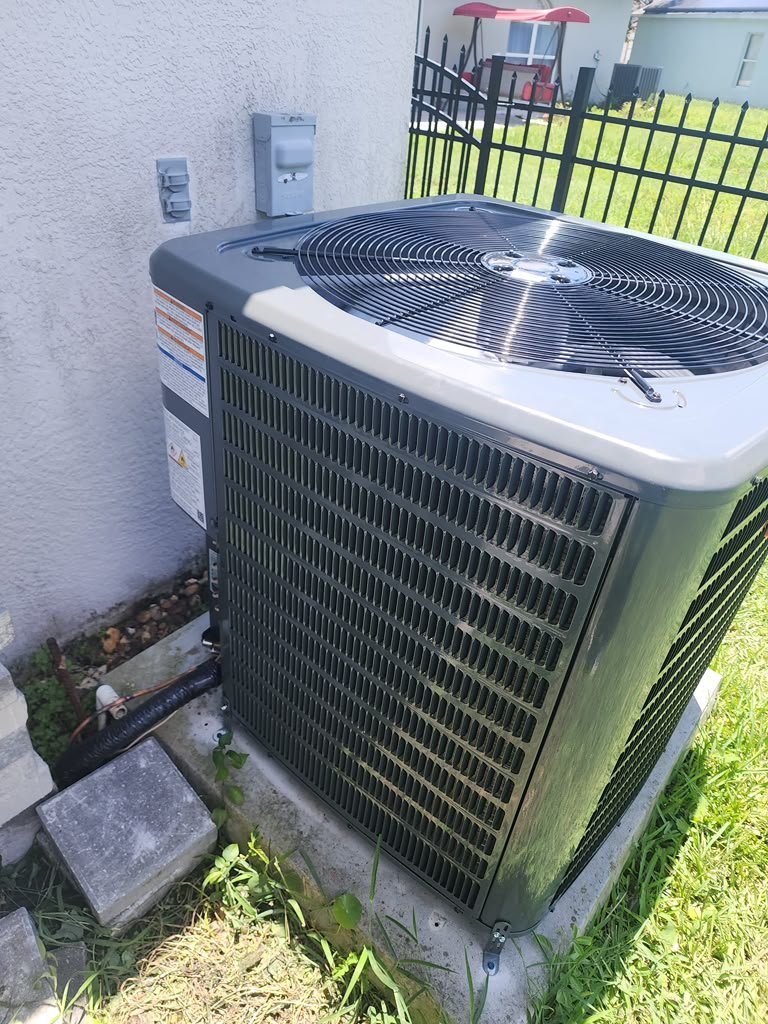 New AC unit on concrete pad beside house in Wesley Chapel, FL 33545. Efficient cooling.