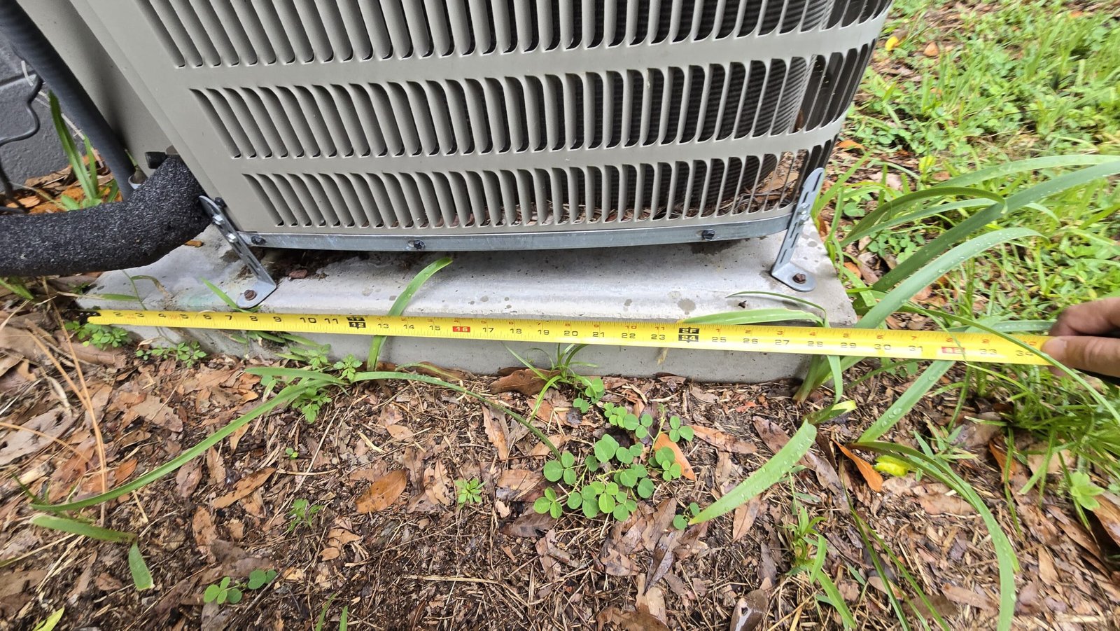 AC unit dimensions shown with measuring tape in Tampa, FL 33613.