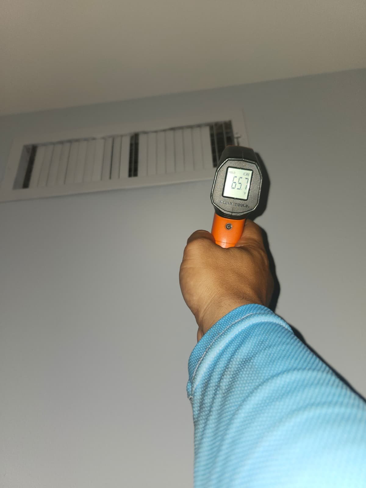 Measuring air temperature at a vent with a thermometer in Tampa, FL 33618. Blower Motor Replacement service.