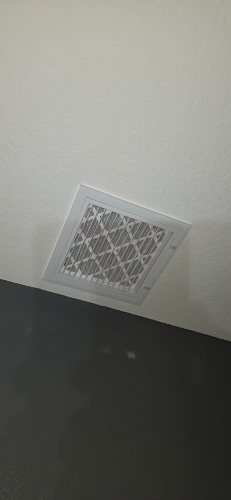 Ceiling vent with filter against dark wall in Wesley Chapel, FL 33545