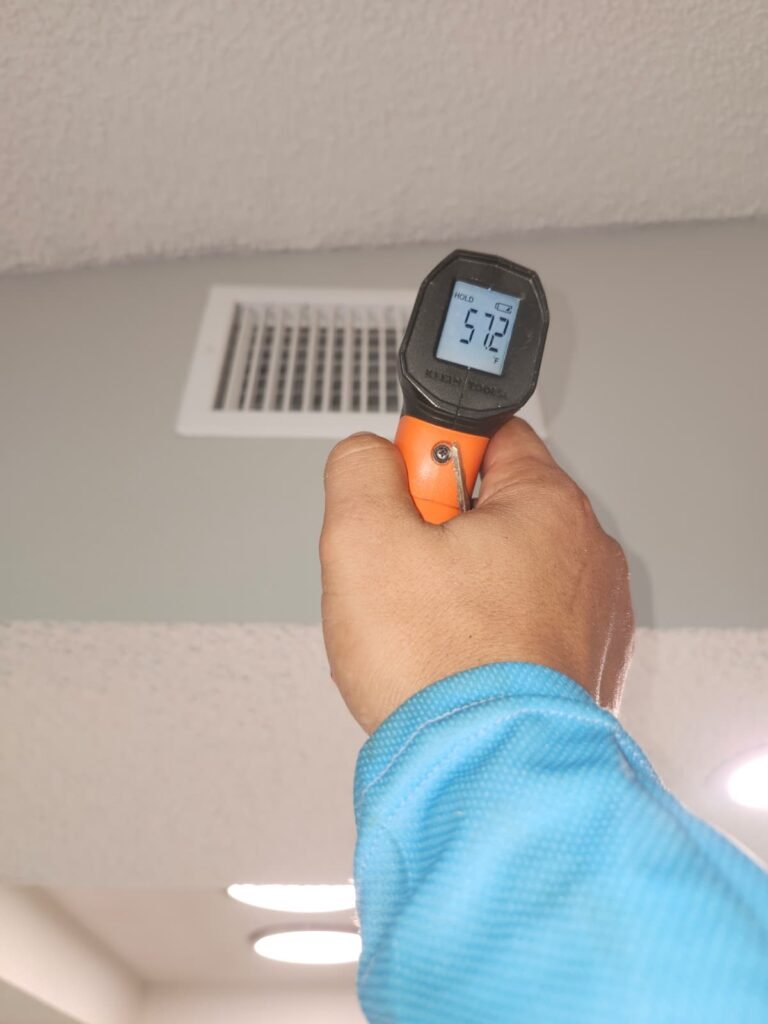 Infrared thermometer reading ceiling vent temperature in Holiday, FL 34691
