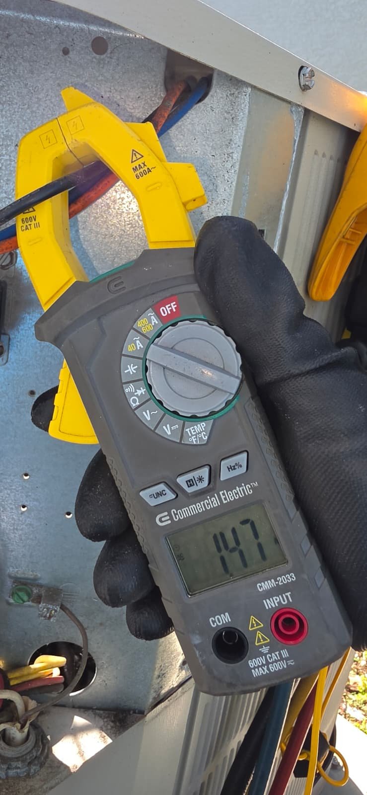 Electric clamp meter measuring current on HVAC unit in Tampa, FL 33624.