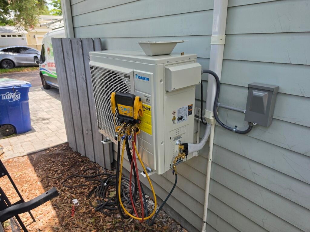 A Daikin heat pump outdoor unit with gauge hoses connected beside a home in Tampa, FL 33629.