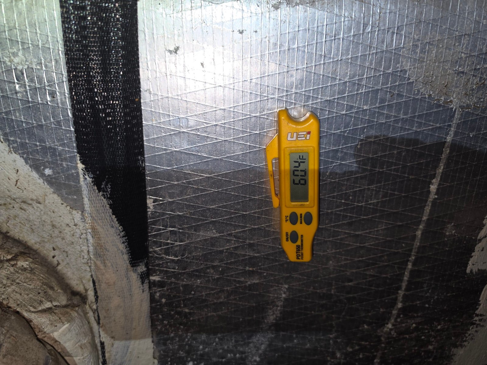 Digital thermometer reading temperature on ductwork in Tampa, FL 33605.