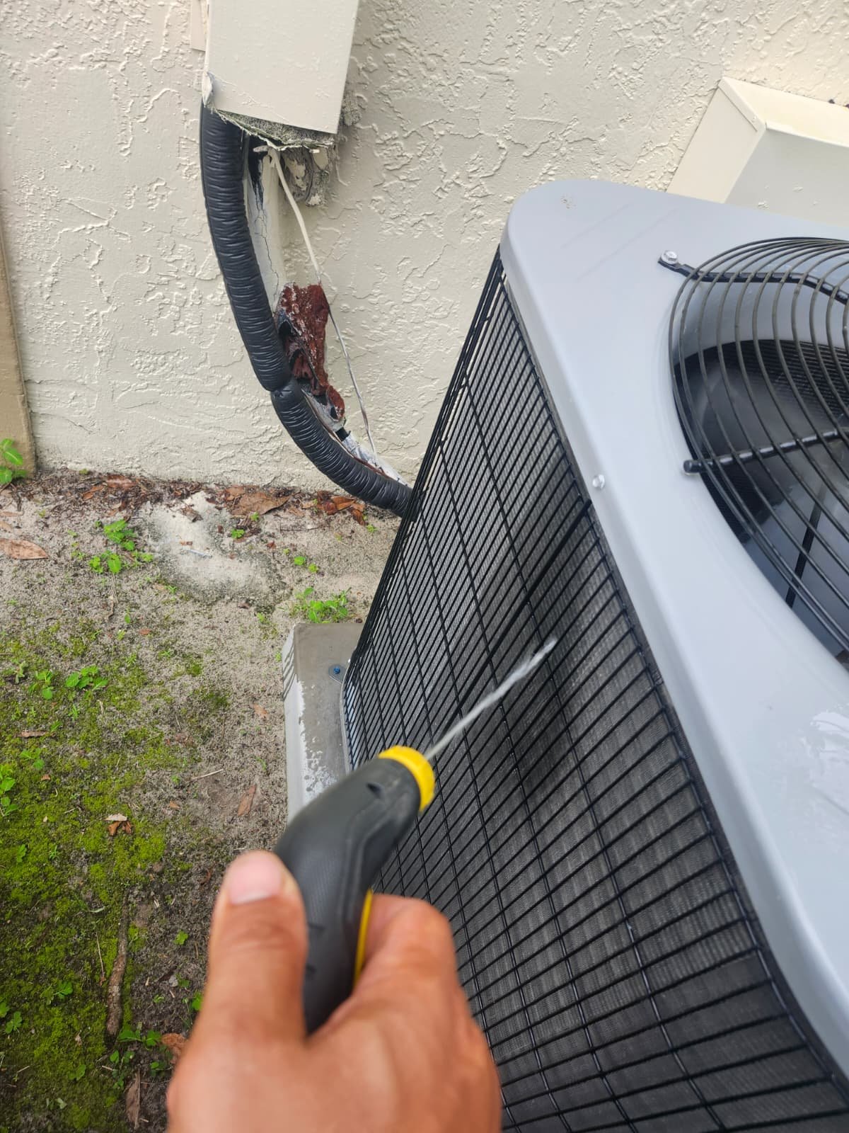 Exterior AC Cleaning in Tarpon Springs, FL 34688 Exterior AC unit cleaning with water spray in Tarpon Springs, FL 34688. Quality HVAC service.