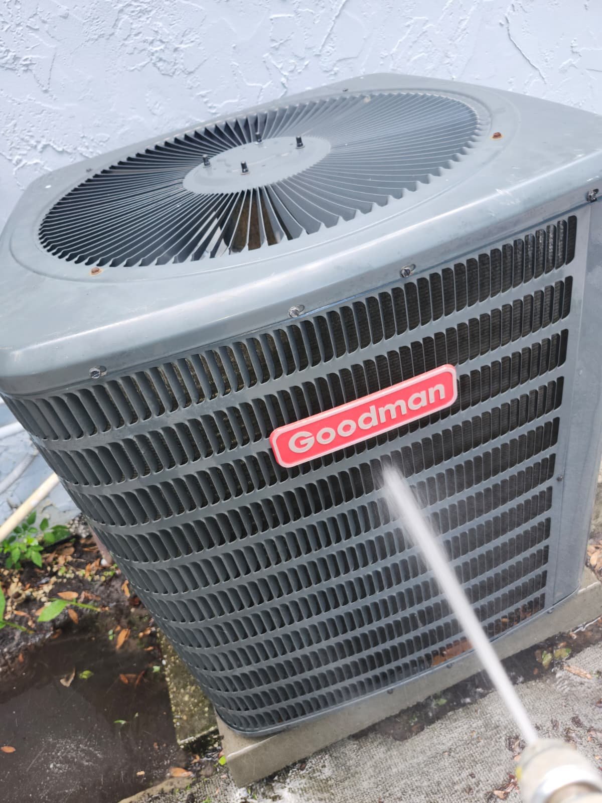 Goodman AC unit being cleaned with water spray in Tampa, FL 33607.
