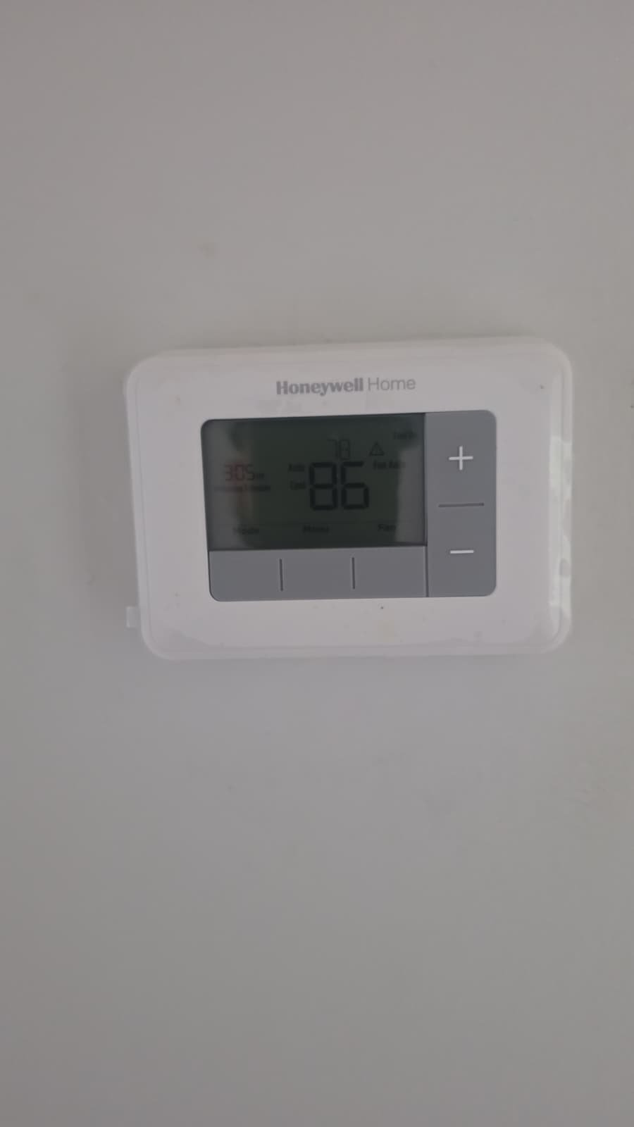 Honeywell thermostat displaying temperature on wall, Tampa, FL 33618.