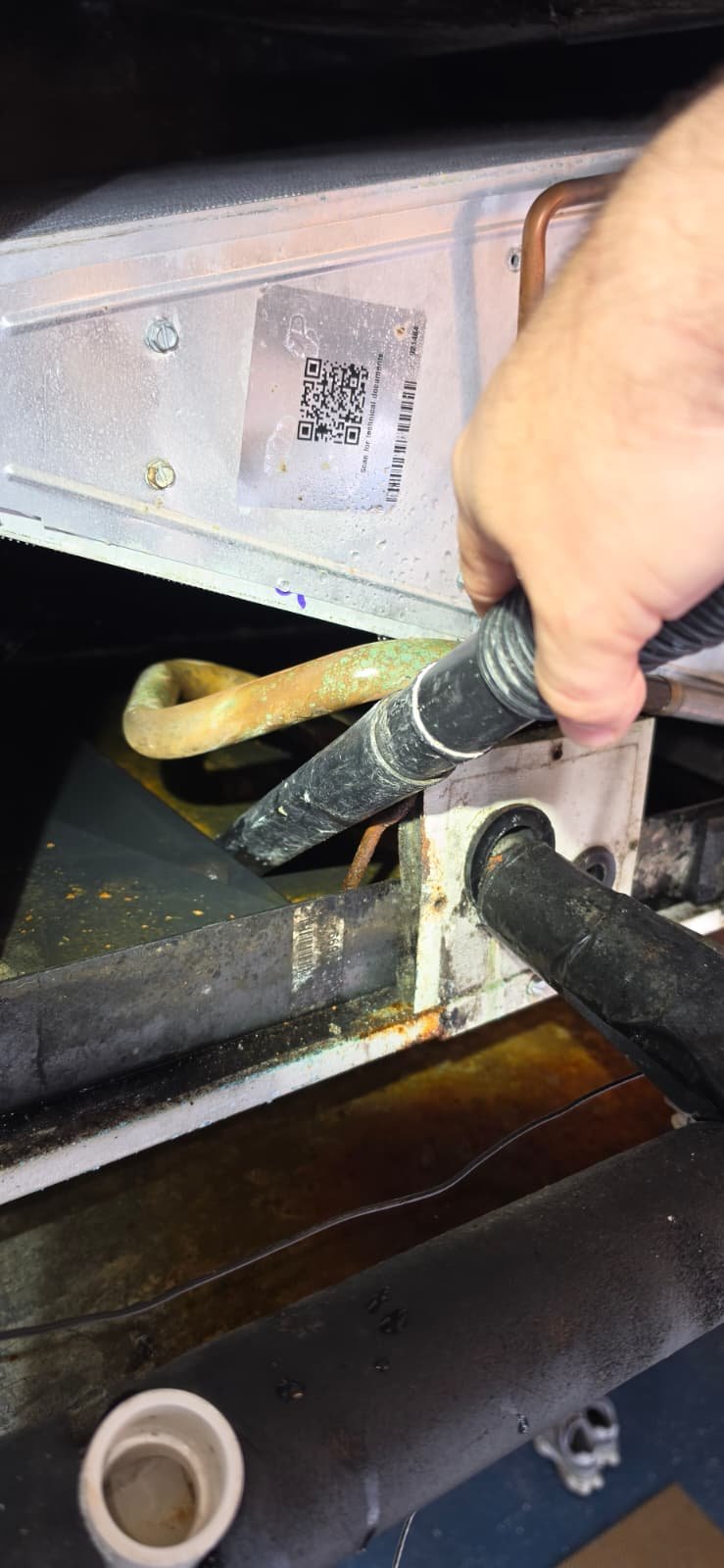 Technician cleaning HVAC component in Tampa, FL 33624.