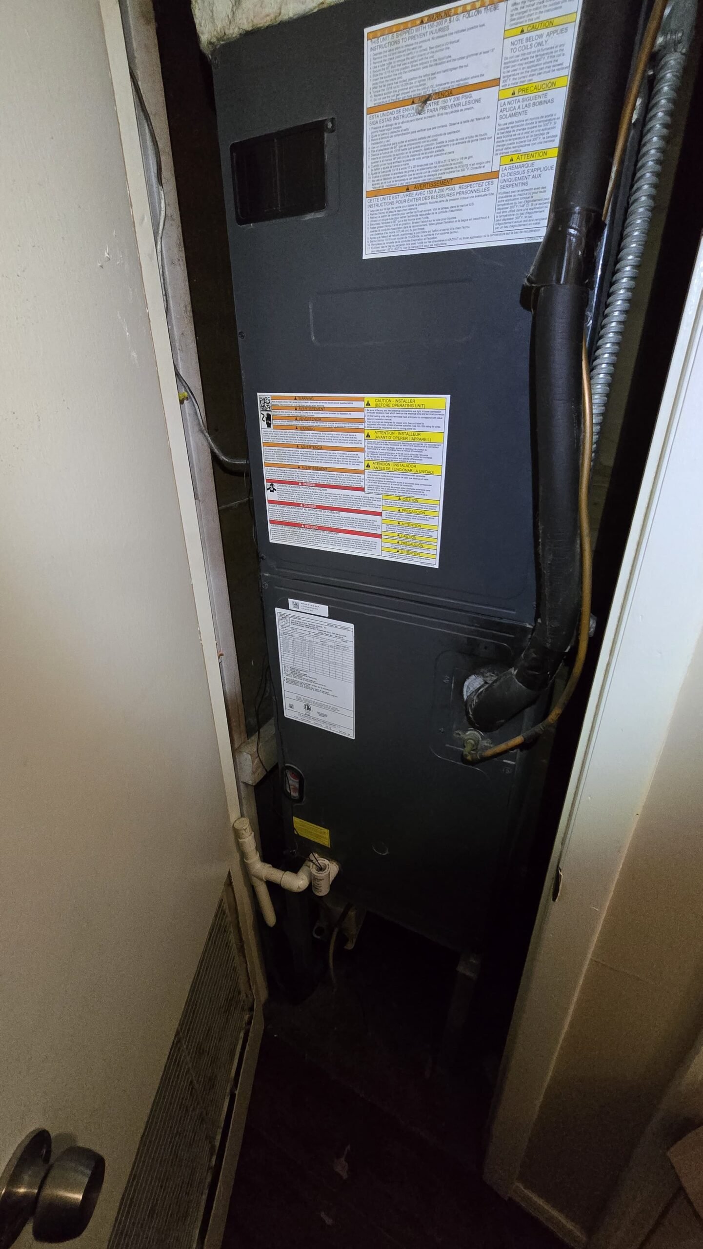 HVAC unit with piping and labels in closet, Tampa, FL 33613.