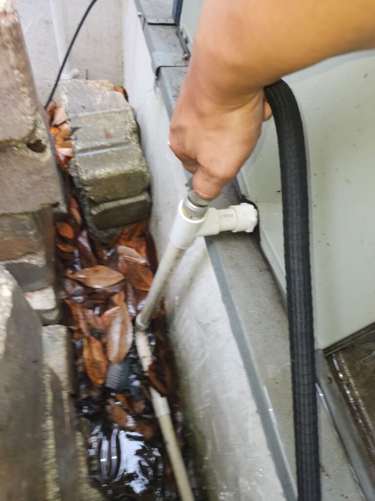 Hand holding hose near HVAC unit during cleaning in Tampa, FL 33609
