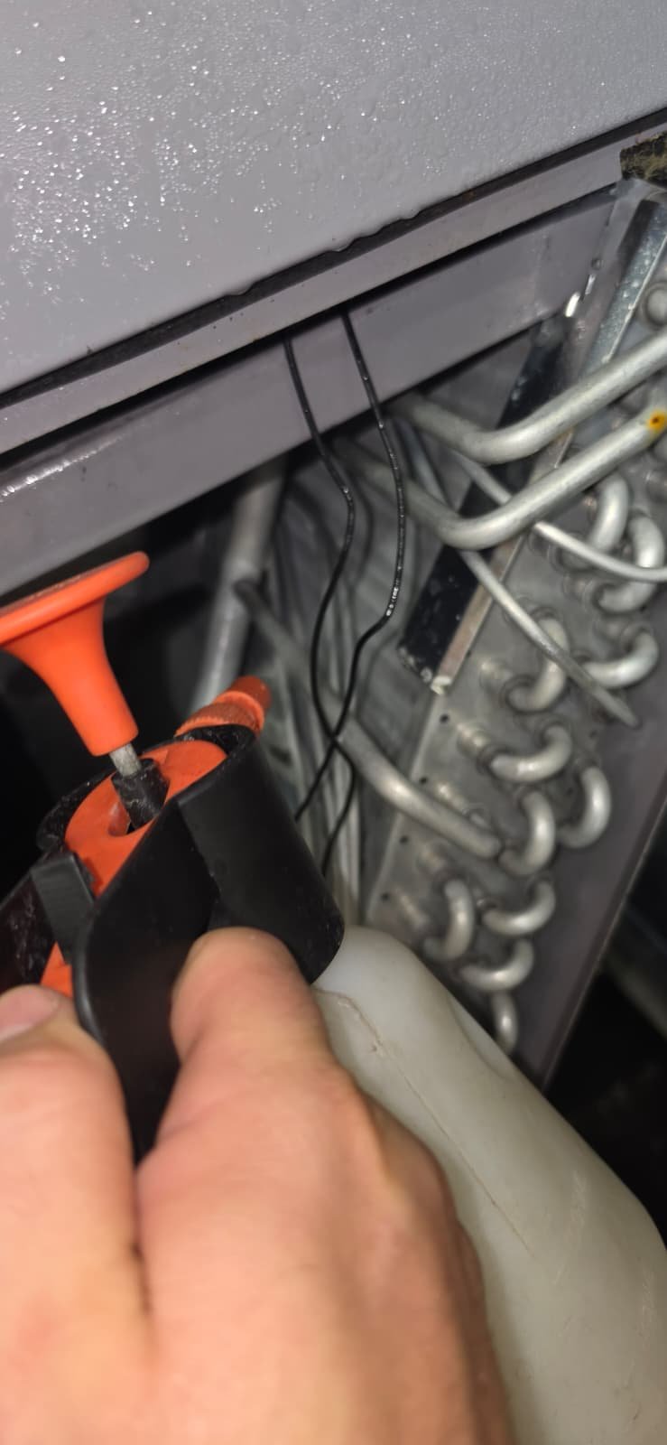 Technician working on HVAC unit wiring in Lutz, FL 33559 during Visit #4.