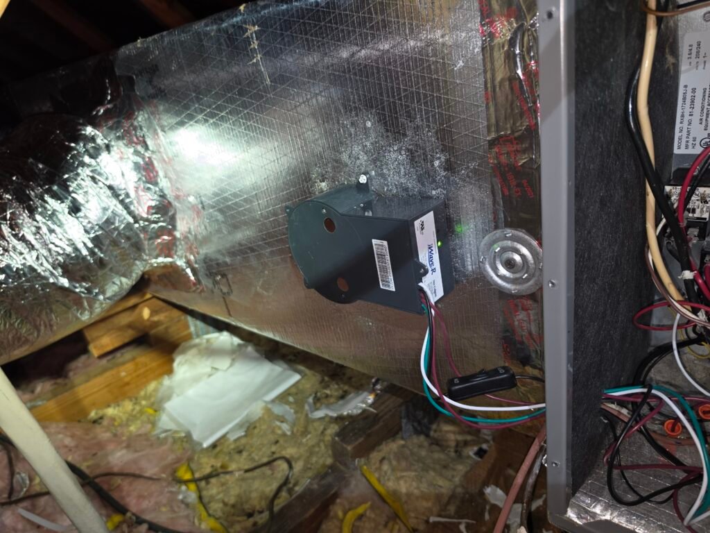 An iWave-R air purifier mounted on the duct plenum beside an attic air handler in Port Richey, FL 34668.