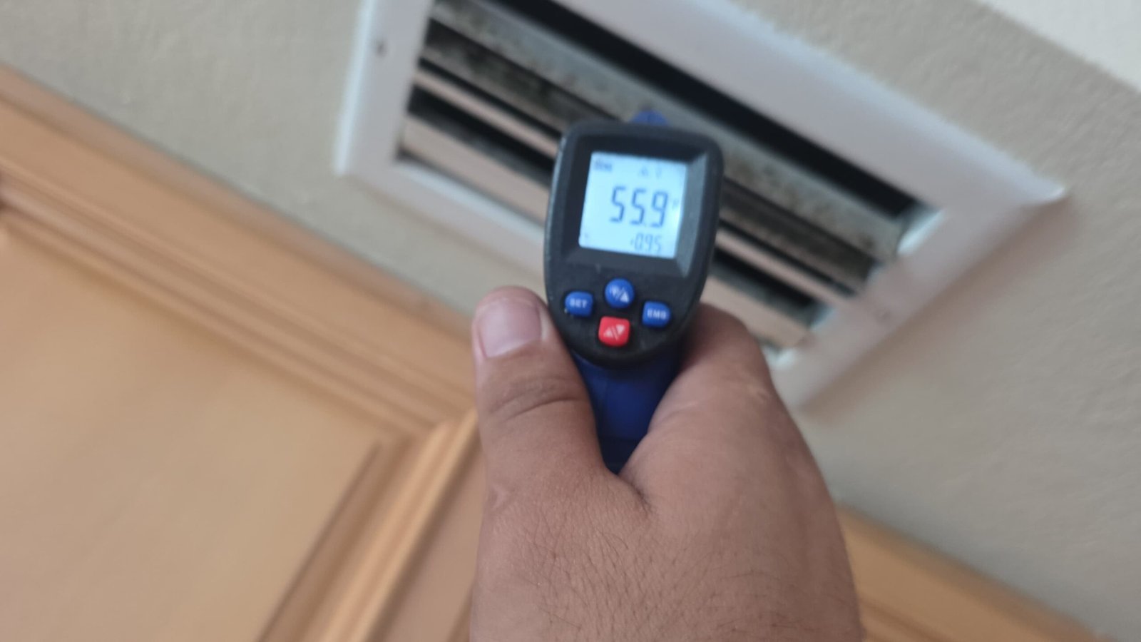 Infrared thermometer measuring vent temperature for AC service in Largo, FL 33771.