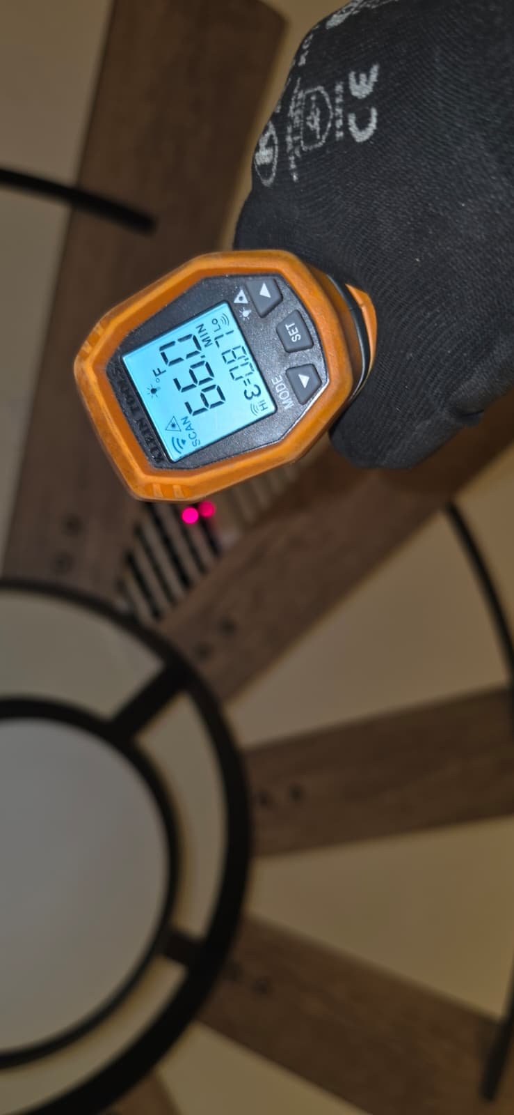 Infrared thermometer reading temperature near ceiling vent in Odessa, FL 33556. Accurate measurement.