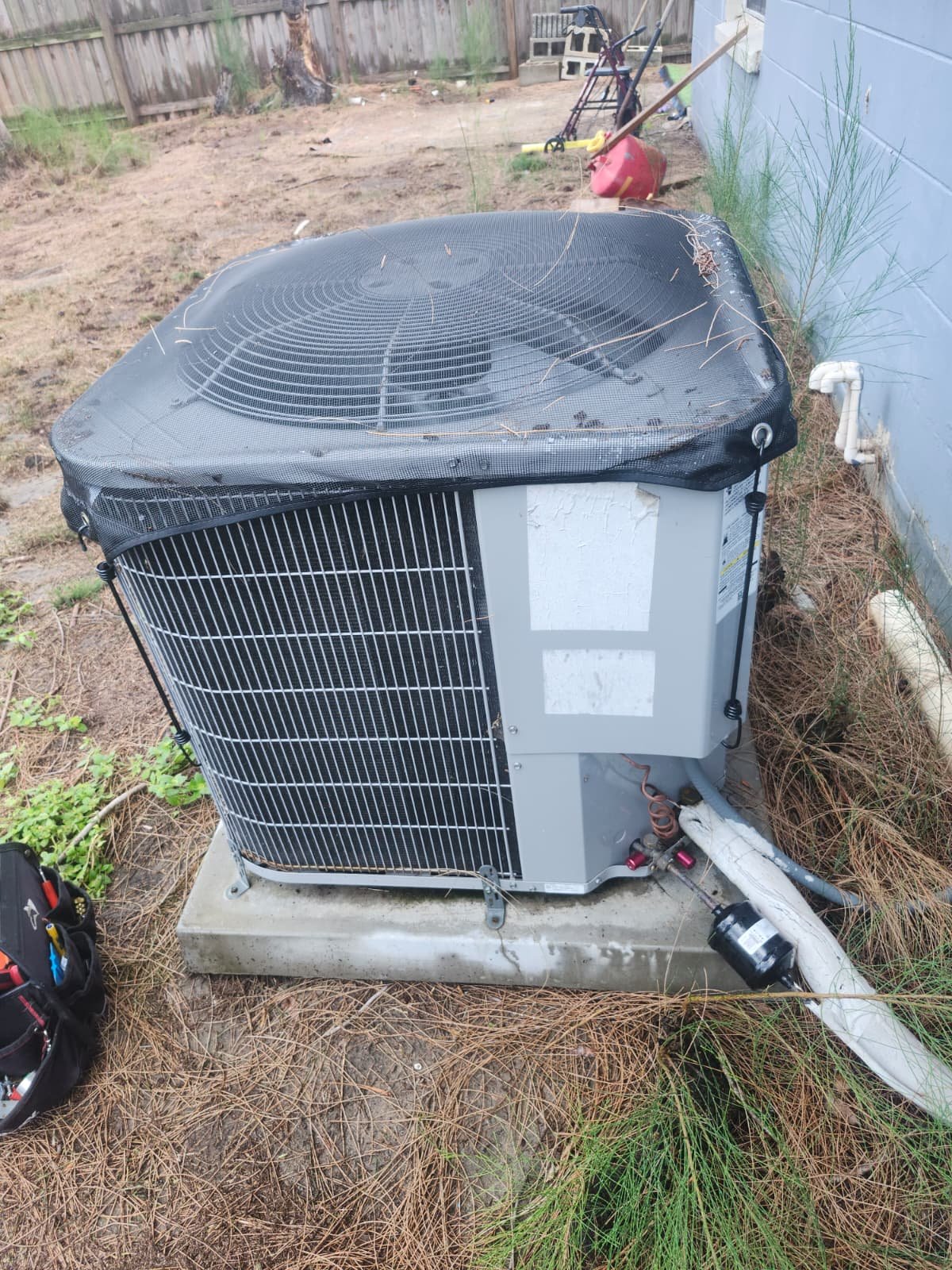 Installed AC unit with protective cover on concrete pad after Visit #3 in Tampa, FL 33619.