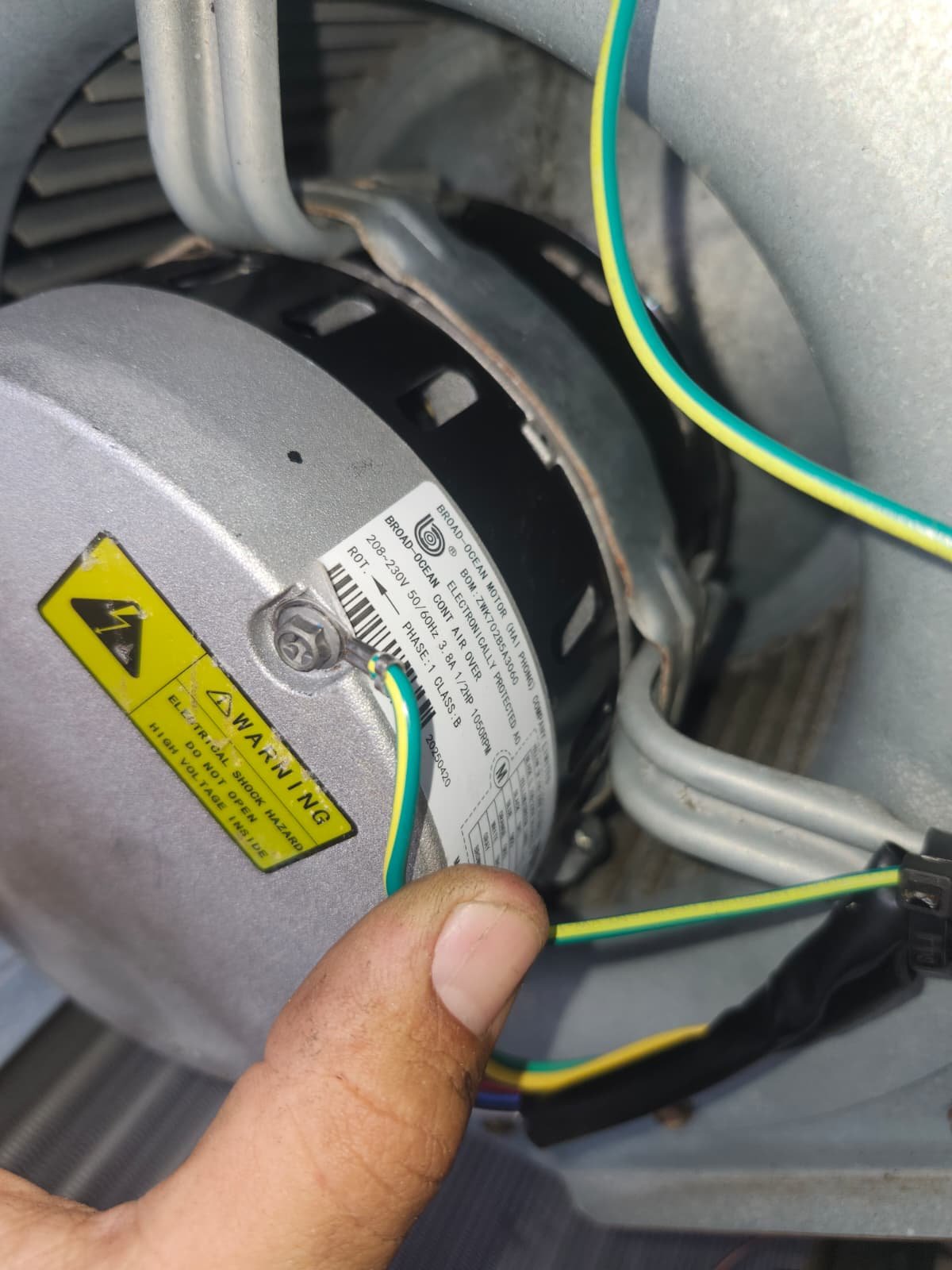 Blower motor installed with visible wiring and hand pointing in Tampa, FL 33618. HVAC work in progress.