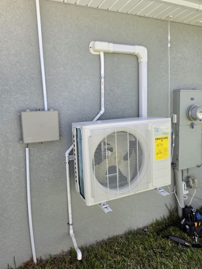 A mini split outdoor unit on a wall bracket with a line cover and drain in Zephyrhills, FL 33541.
